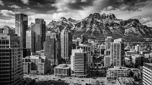 Mountain range behind modern corporate skyscrapers, black and white
